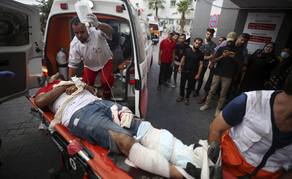 Medics move Osama Dueij, 32, who was shot in the leg by Israeli troops during a violent protest at the Gaza Strip's border with Israel, into the treatment room of Shifa hospital in Gaza City, Saturday, Aug. 21, 2021. (AP Photo/Abdel Kareem Hana)