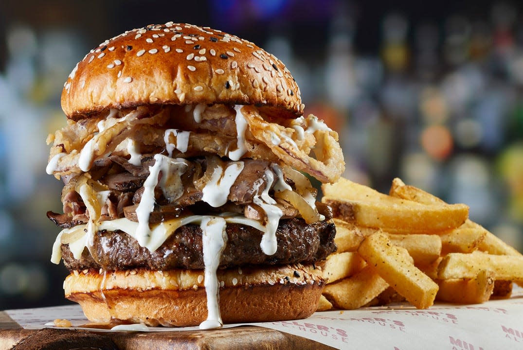 The Prime Burger is available at Mount Dora Miller's Ale House, featuring cheese, shaved prime rib, roasted mushrooms, sautéed onions, gravy, crispy onion tanglers and garlic crema, on a toasted black and white sesame seed bun. Served with French fries.