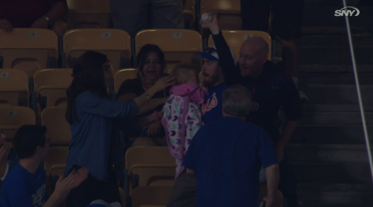 This Mets fan caught the ball while holding his baby, but mom didn't seem very amused. (MLB.TV)