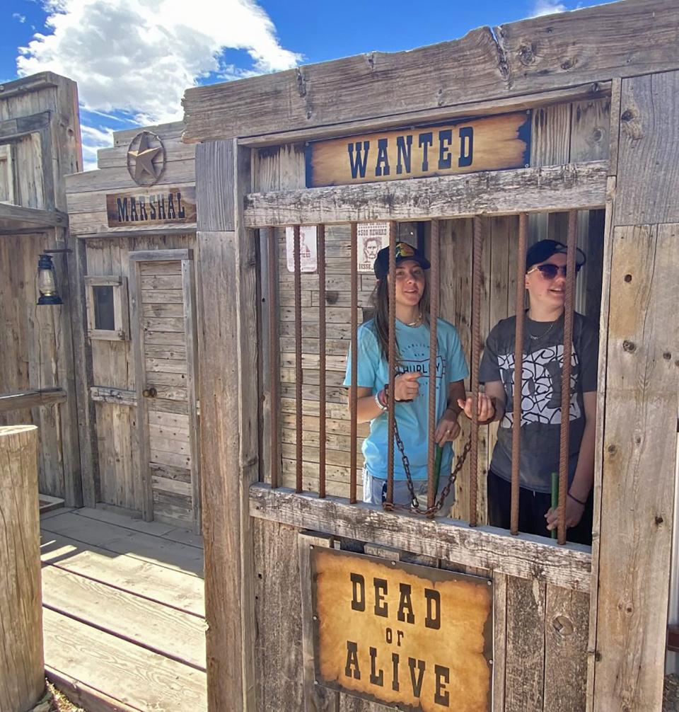 Ally Caldwell (left) and Abigale Beeler check out the jail that is part of the Old West-themed mini golf course.