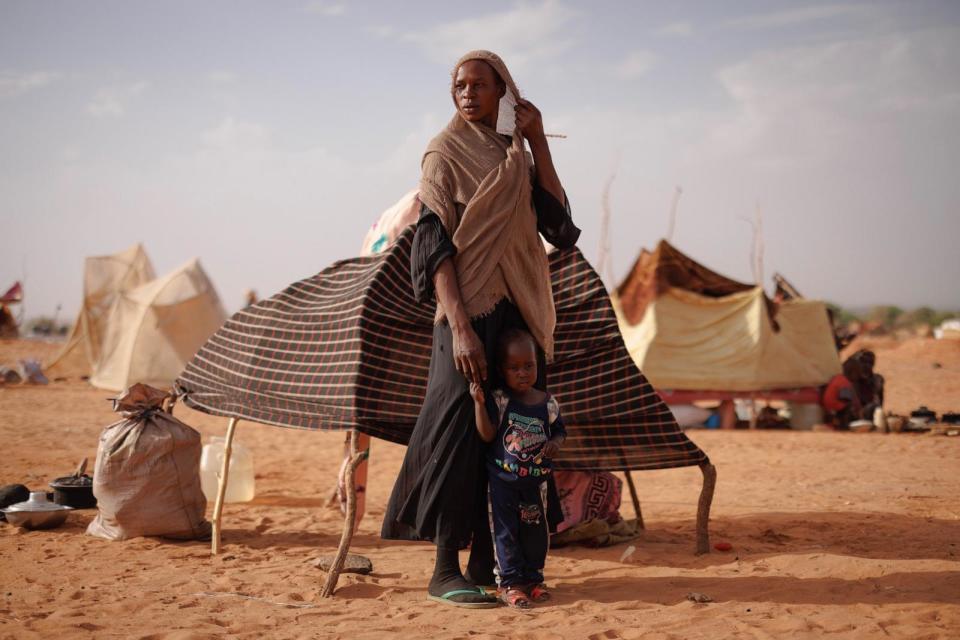 PHOTO: Newly arrive refugees stand outside their makeshift shelter as a sand storm approaches on April 21, 2024 in Adre, Chad.  (Dan Kitwood/Getty Images)
