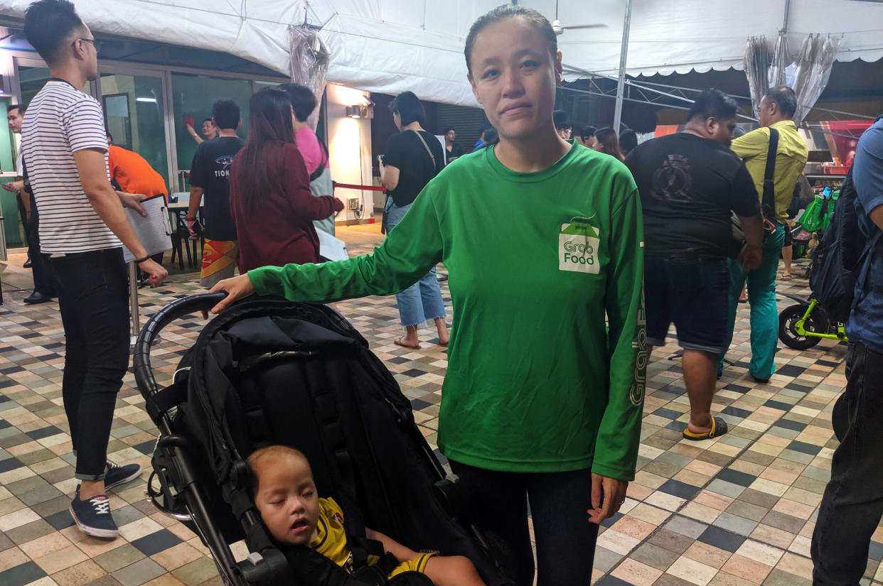 Eileen Ho, 28, a rider for GrabFood and Foodpanda, posing with her 1-year-old child outside the Anchorvale Community Club's multi-purpose hall where the dialogue session with SMS for Transport and Sengkang West MP Lam Pin Min was held on 12 November, 2019. (PHOTO: Yahoo News Singapore)