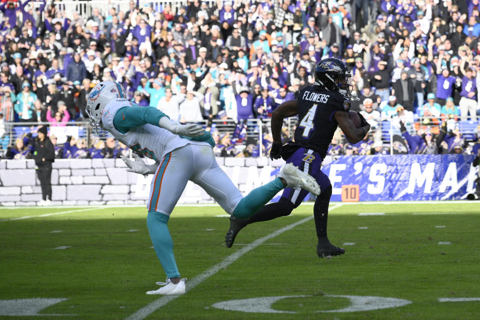 Baltimore Ravens wide receiver Zay Flowers (4) runs past Miami Dolphins cornerback Eli Apple (33) for a touchdown during the first half of an NFL football game in Baltimore, Sunday, Dec. 31, 2023. (AP Photo/Nick Wass)