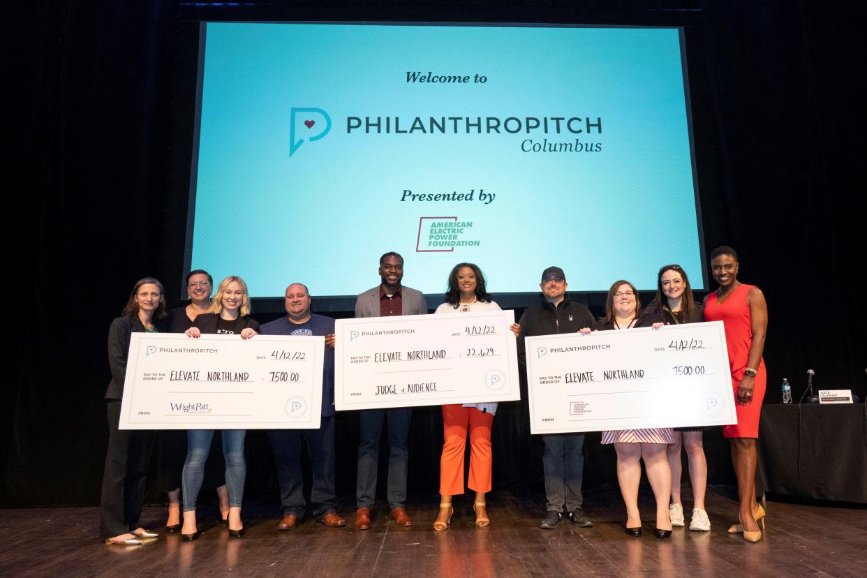 Elevate Northland Executive Director Judith Cockrell, fifth from right, poses with Philanthropitch judges as they hold up checks the organization won last month. The nonprofit was awarded more than $37,000 for its proposal to open a halal kitchen at the Northland community center.