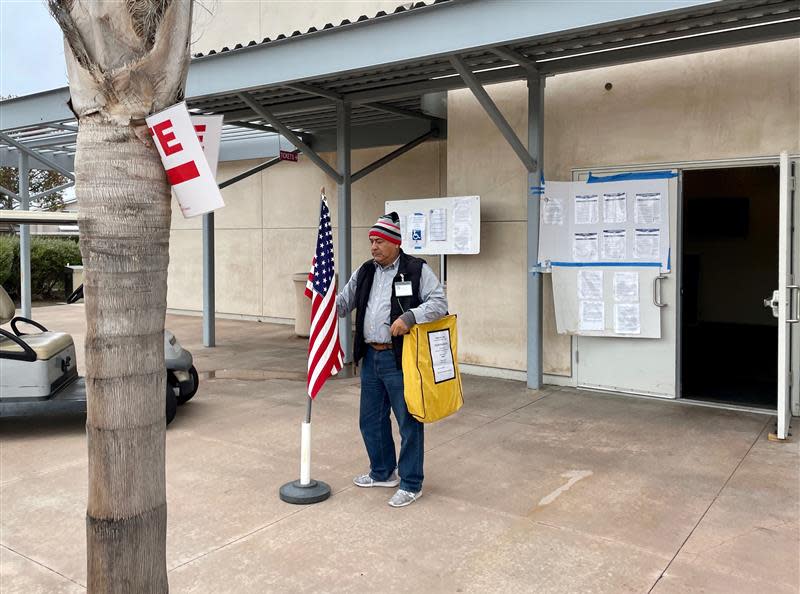 Joe Belmont sets up a flag outside of the vote center at Oxnard College's Performing Arts Center on Nov. 8, 2022.