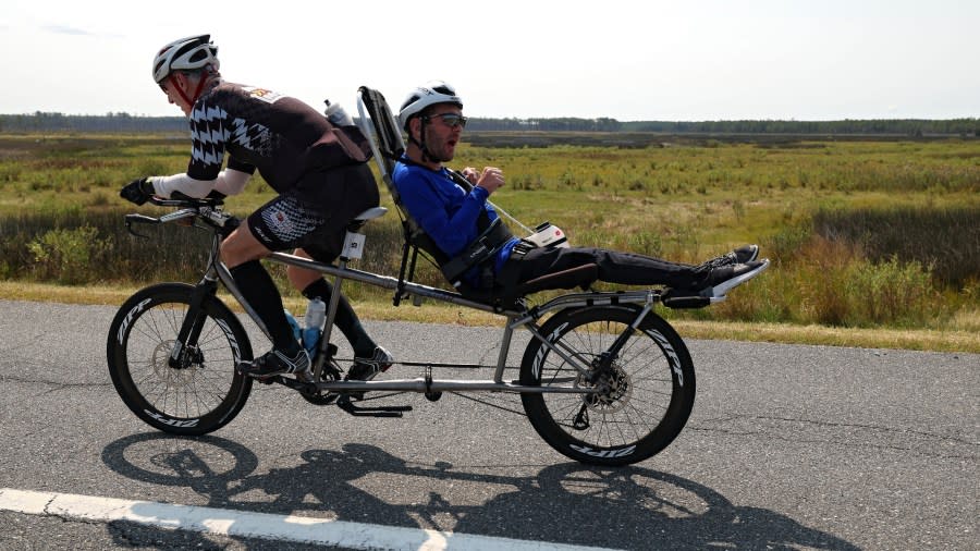 Jeff Agar (L) and son Johnny Agar (R) compete in the bike portion of the Qatar Airways IRONMAN Maryland on September 17, 2022, in Cambridge, Maryland. (Photo by Patrick Smith/Getty Images for IRONMAN)