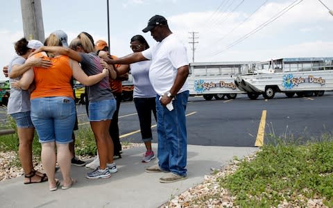 People pray outside Ride the Ducks facility in Branson, Missouri - Credit: Charlie Riedel/AP