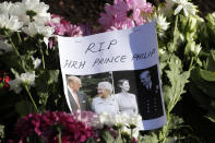 A message is left amoungst flowers outside Windsor Castle in Windsor, England Sunday, April 11, 2021. Britain's Prince Philip, the irascible and tough-minded husband of Queen Elizabeth II who spent more than seven decades supporting his wife in a role that mostly defined his life, died on Friday. (AP Photo/Kirsty Wigglesworth)