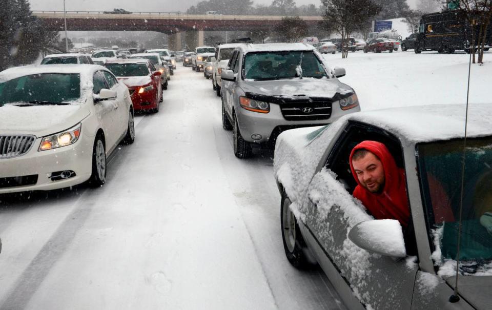 Kevin Miller looks out of the passenger window of his friend’s car as they sit in stuck traffic Wednesday afternoon Feb. 12, 2014 after snow and ice caused massive traffic jams in Raleigh, NC.
