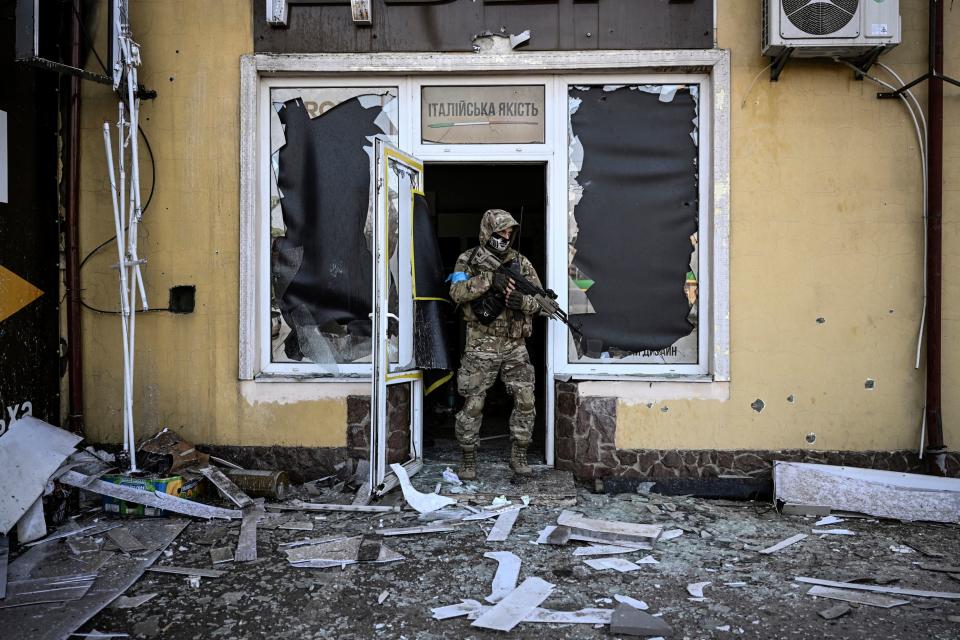 CORRECTION / A Ukrainian serviceman exits a damaged building after shelling in Kyiv, on March 12, 2022. Russian forces are positioned around Kiev on March 12, 2022 and are 