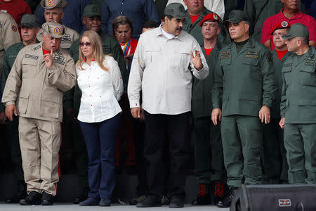 Venezuela's President Nicolas Maduro talks to Venezuela's Defense Minister Vladimir Padrino Lopez and Remigio Ceballos Strategic Operational Commander of the Bolivarian National Armed Forces, as Venezuela's National Constituent Assembly President Diosdado Cabello talks to Cilia Flores, wife of Venezuela's President Nicolas Maduro, during a ceremony to mark the 17th anniversary of the return to power of Venezuela's late President Hugo Chavez after a coup attempt and the National Militia Day in Caracas, Venezuela April 13, 2019. REUTERS/Carlos Garcia Rawlins