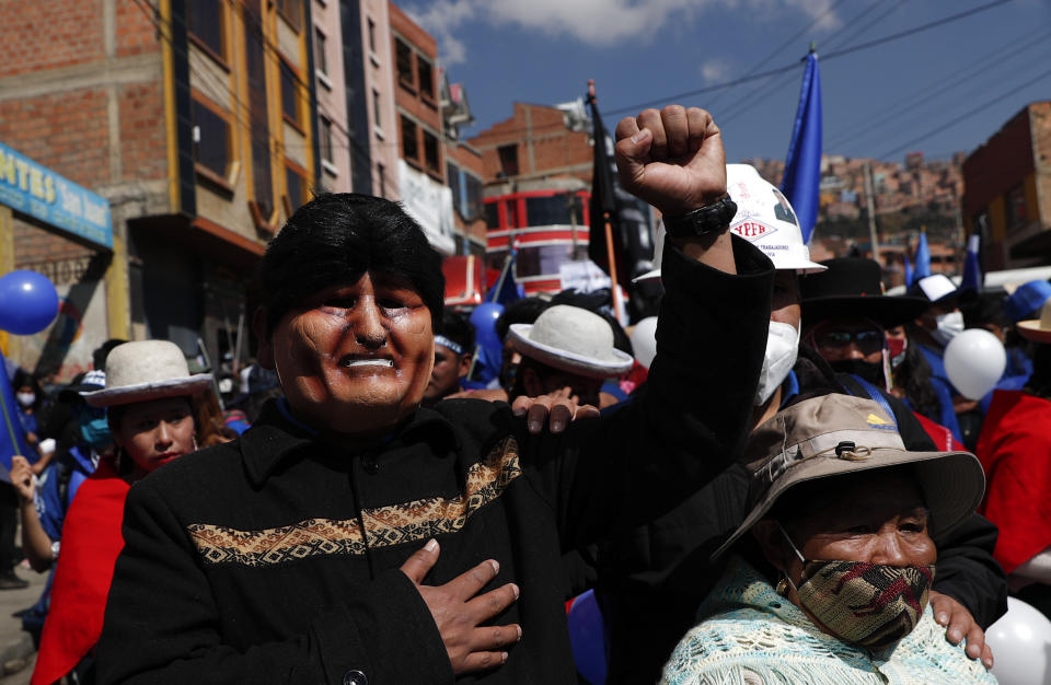 FILE - In this Sept. 19, 2020 file photo, a supporter, wearing a mask depicting former President Evo Morales, strikes a pose during a campaign rally for Luis Arce Catacora, the Bolivian presidential candidate for the Movement Towards Socialism Party, or MAS, in La Paz, Bolivia. MAS is the party founded by Morales who was ousted in November 2019, after several weeks of demonstrations that erupted over allegations of fraud in last year's October presidential election that Morales claimed to have won. (AP Photo/Juan Karita, File)