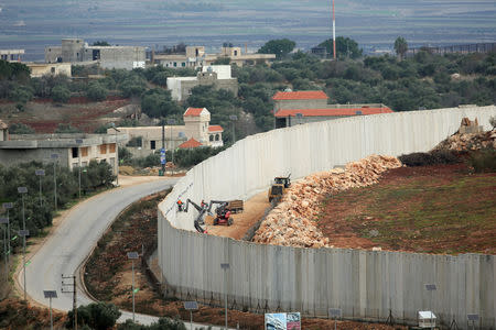 An Israeli crane is seen by a wall built near the border, as seen from Lebanon, near the village of Kfarkila, in south Lebanon November 27, 2018. REUTERS/Ali Hashisho