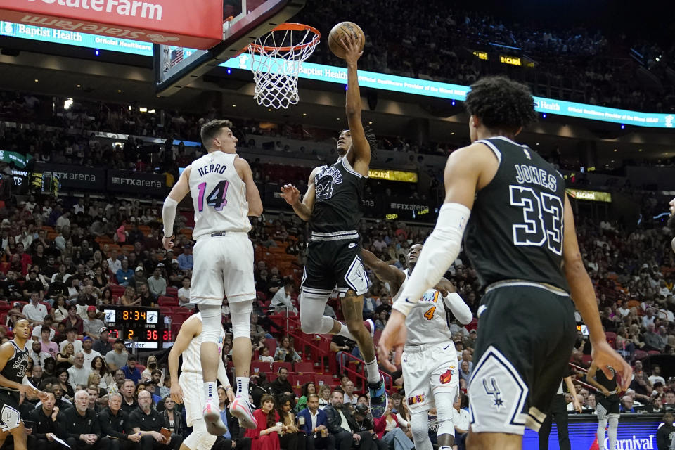 San Antonio Spurs guard Devin Vassell (24) shoots over Miami Heat guard Tyler Herro (14) during the first half of an NBA basketball game, Saturday, Dec. 10, 2022, in Miami. (AP Photo/Lynne Sladky)