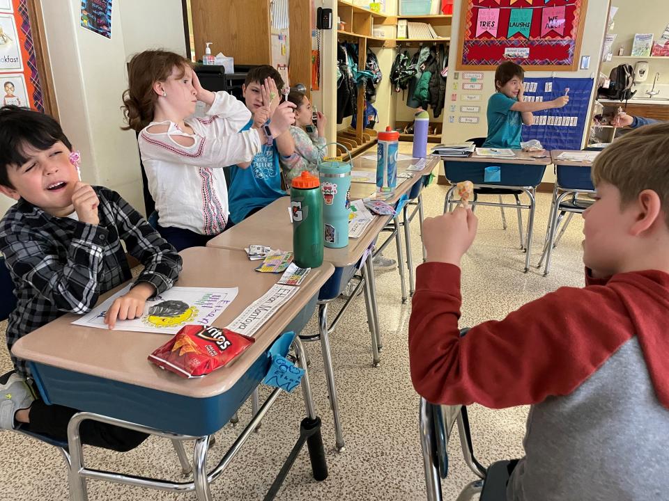 Second-graders at Indian Landing Elementary School in Penfield use a lollipop to cast a moon-like shadow during a visit from the Penfield High School Eclipse Club March 19, 2024.