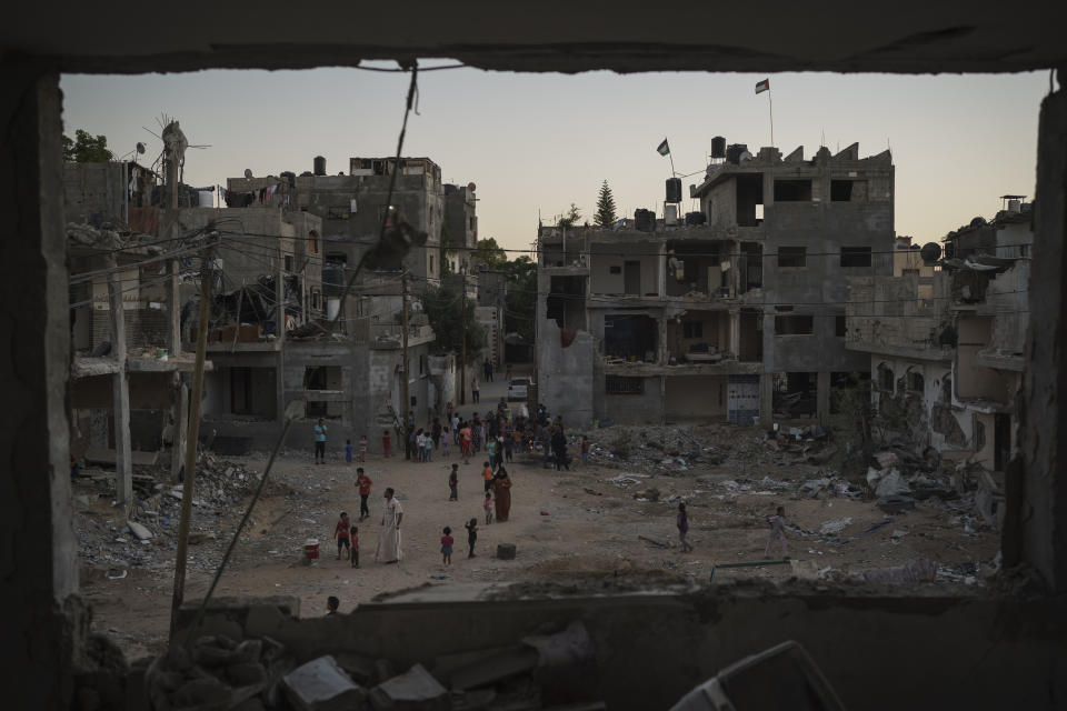 Palestinians walk along Al-Baali Street next to debris of homes heavily damaged by airstrikes during an 11-day war between Israel and Hamas, the militant group that controls Gaza, in Beit Hanoun, northern Gaza Strip, Wednesday, June 16, 2021. Since 2008, more than 4,000 Palestinians have been killed in four wars, according to the United Nations. (AP Photo/Felipe Dana)