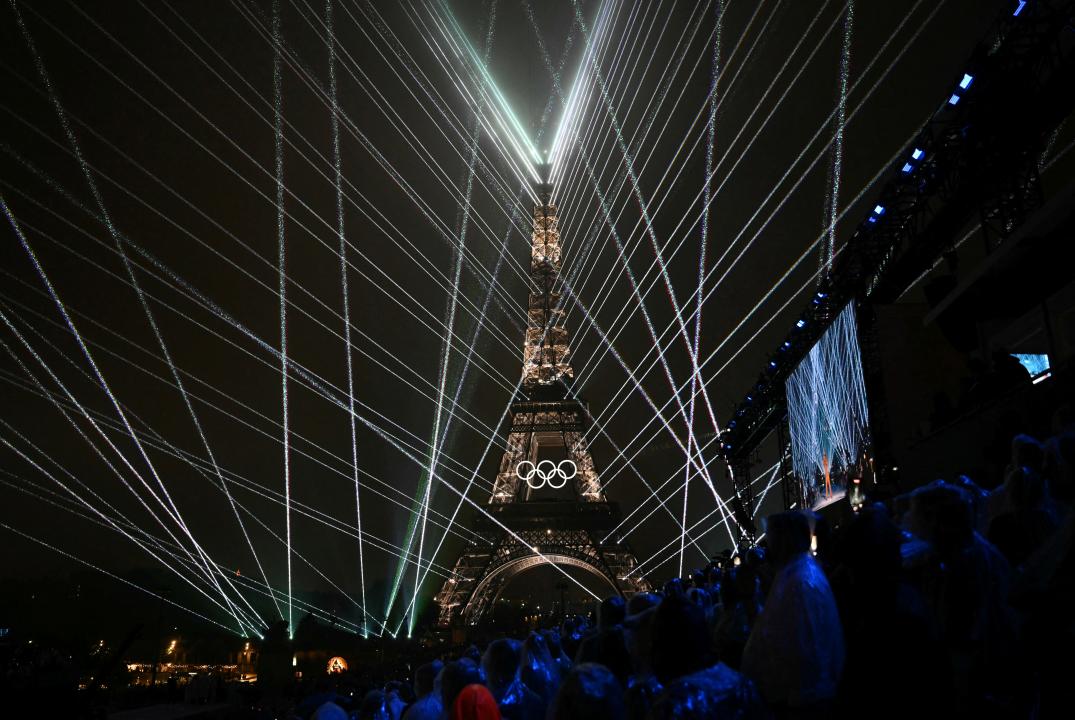 A general view of the Trocadero venue, with the Eiffel Tower looming in the background 
and lasers lighting up the sky, during the opening ceremony of the Paris 2024 Olympic Games on July 26, 2024. (Photo by Jonathan NACKSTRAND / AFP) (Photo by JONATHAN NACKSTRAND/AFP via Getty Images)