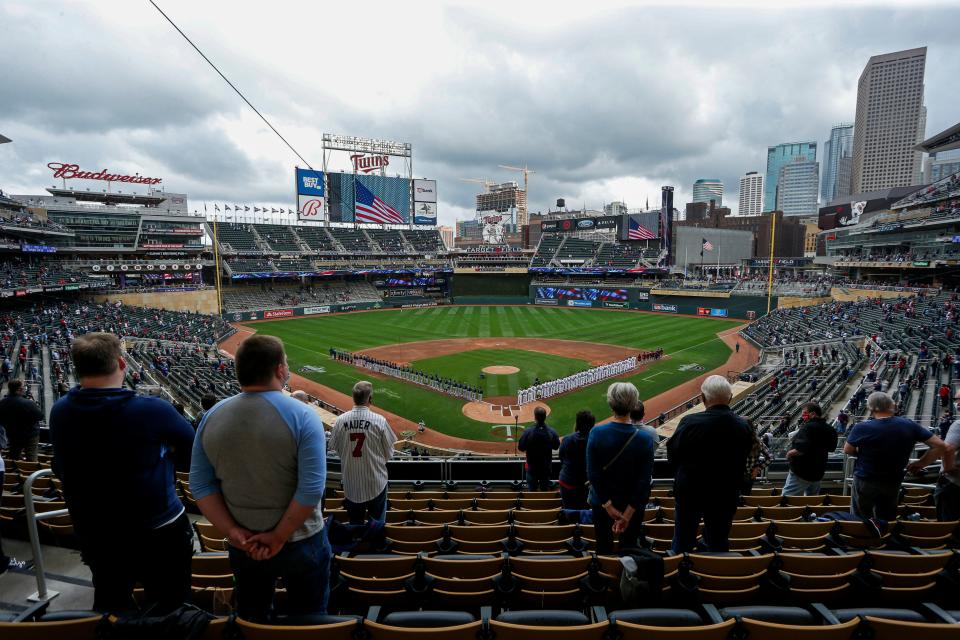 he Seattle Mariners and Minnesota Twins stand along the baselines and fans stand for the national anthem for the home opener baseball game at Target Field Thursday, April 8, 2021, in Minneapolis.