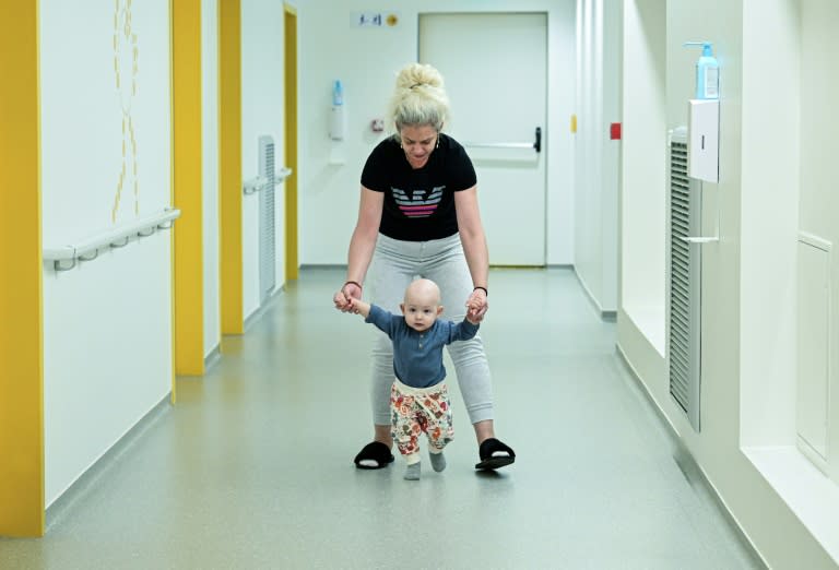 Ildiz Ivan et son fils de 15 mois, Eric, atteint d'une tumeur au cerveau, dans un couloir du nouvel hôpital pour enfants construit grâce à des dons privés, le 18 avril 2024 à Bucarest, en Roumanie (Daniel MIHAILESCU)