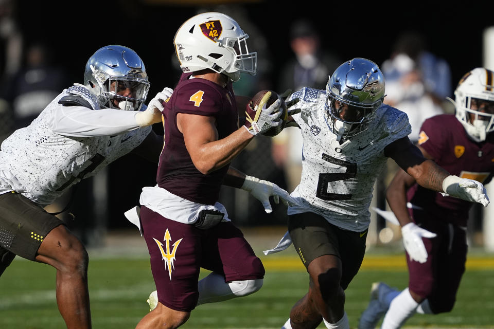 Arizona State running back Cameron Skattebo (4) runs as Oregon linebacker Jeffrey Bassa (2) pursues during the first half on an NCAA college football game, Saturday, Nov. 18, 2023, in Tempe, Ariz. (AP Photo/Matt York)