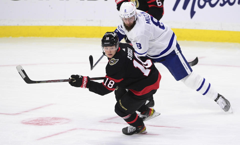 Ottawa Senators left wing Tim Stutzle (18) skates around Toronto Maple Leafs defenceman Jake Muzzin (8) during the second period of an NHL hockey game Friday, Jan. 15, 2021, in Ottawa, Ontario. (Sean Kilpatrick/The Canadian Press via AP)