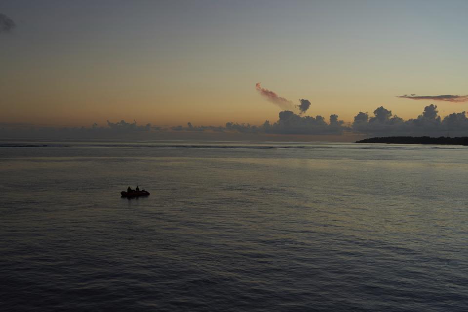 The sun sets behind the tiny island of Alphonse in Seychelles, Wednesday March 13, 2019. A mission to recover an ROV (Remotely Operated Vehicle) stranded on the seabed went late into the evening as submersibles struggled to reach the underwater drone. The camera-carrying ROV is a vital image-gathering tool that can go deeper than the submersibles. (AP Photo/David Keyton)