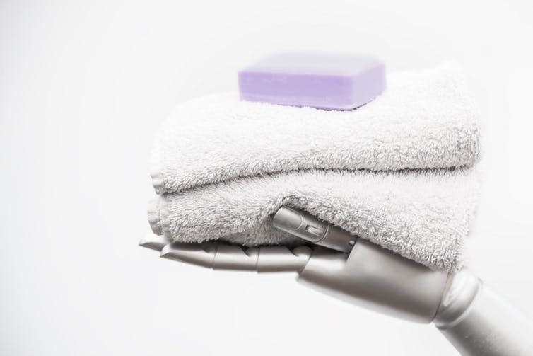 <span class="caption">Folding towels – not so easy when you’re a robot.</span> <span class="attribution"><a class="link " href="https://www.shutterstock.com/image-photo/robotic-arm-holds-terry-towels-bar-1286298154?src=2KWq8p8yNaGVkxYt5OLBcw-1-4&studio=1" rel="nofollow noopener" target="_blank" data-ylk="slk:Tanja Esser/Shutterstock;elm:context_link;itc:0;sec:content-canvas">Tanja Esser/Shutterstock</a></span>