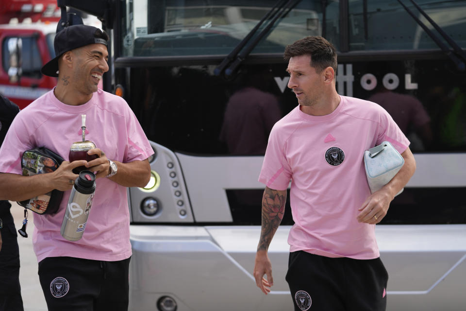 Inter Miami forwards Luis Suarez, left, and Lionel Messi talk as they arrive for the team's MLS soccer match against St. Louis City, Saturday, June 1, 2024, in Fort Lauderdale, Fla. (AP Photo/Rebecca Blackwell)