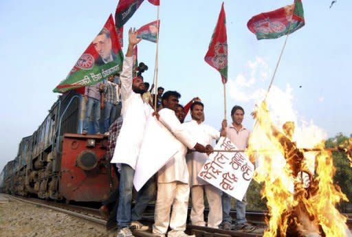 Samajwadi Party activists burn an effigy of Indian Prime Minister Manmohan Singh after stopping a train during a strike against a petrol price hike in Allahabad on May 31, 2012. India's opposition parties held a nationwide strike May 31, vowing to shut down the country to protest against petrol price rises announced last week. AFP PHOTO/STR