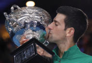 Serbia's Novak Djokovic kisses the Norman Brookes Challenge Cup after defeating Austria's Dominic Thiem in the men's singles final of the Australian Open tennis championship in Melbourne, Australia, early Monday, Feb. 3, 2020. (AP Photo/Lee Jin-man)