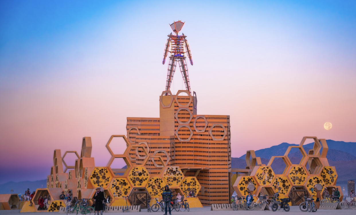 As the sun sets over the Black Rock Desert, Burners gather around the iconic Burning Man structure.