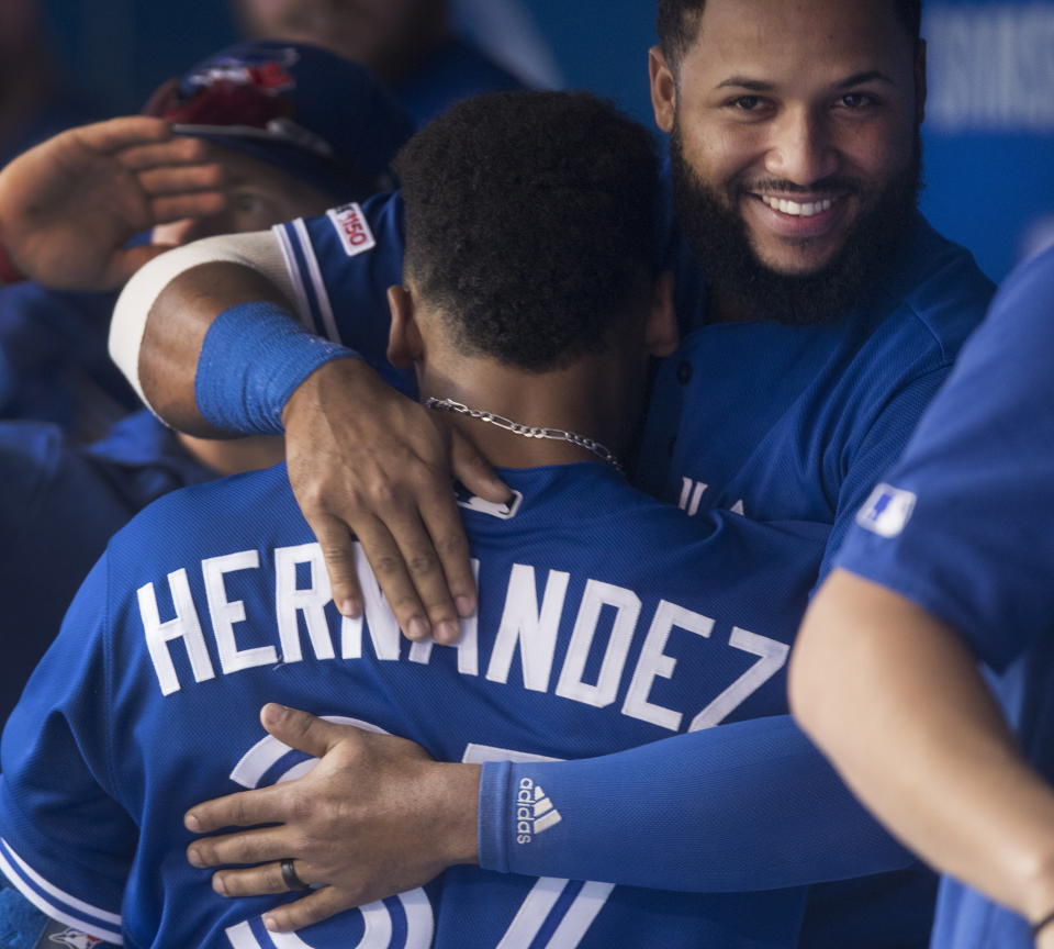 Toronto Blue Jays' Teoscar Hernandez gets a hug from teammate Richard Urena after he hit a home run against the Tampa Bay Rays in a baseball game in Toronto Saturday Sept. 28, 2019. (Fred Thornhill/The Canadian Press via AP)