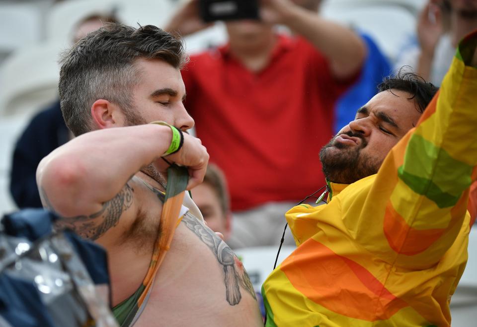 A fan (L) and a volunteer chest pump during the women's beach volleyball qualifying match between the Netherlands and Australia at the Beach Volley Arena in Rio de Janeiro on August 10, 2016, for the Rio 2016 Olympic Games.