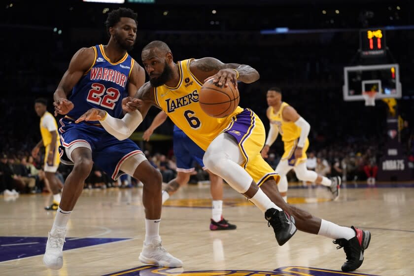 The Lakers' LeBron James drives against the Golden State Warriors' Andrew Wiggins during the first half March 5, 2022.