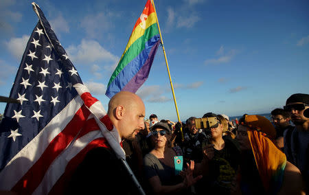 Demonstrator Johnny Benitez (L) faces off against counter-protesters during an America First rally in Laguna Beach, California, U.S., August 20, 2017. REUTERS/Sandy Huffaker