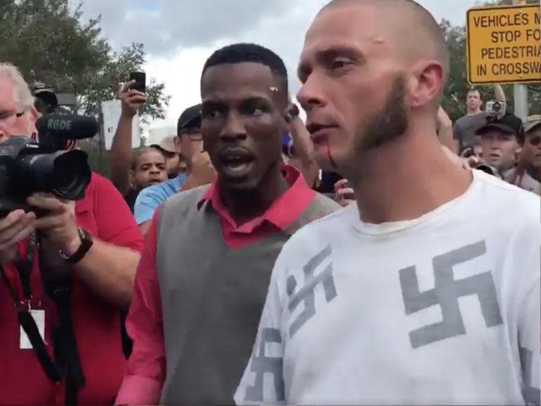 Man wearing shirt covered in swastikas gets punched in head outside Richard Spencer speech