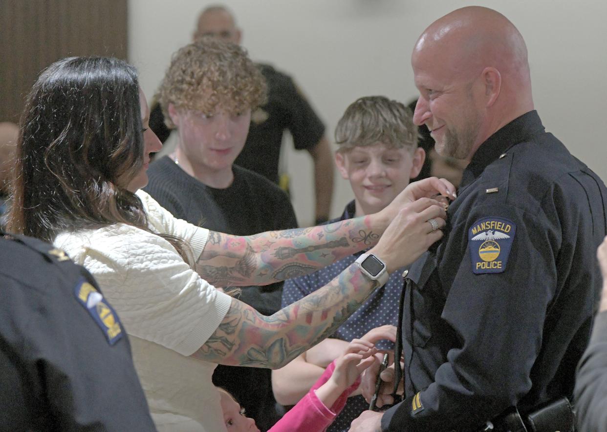 The family of Michael Napier help with the badge pinning ceremony after he was promoted to assistant chief Thursday afternoon.