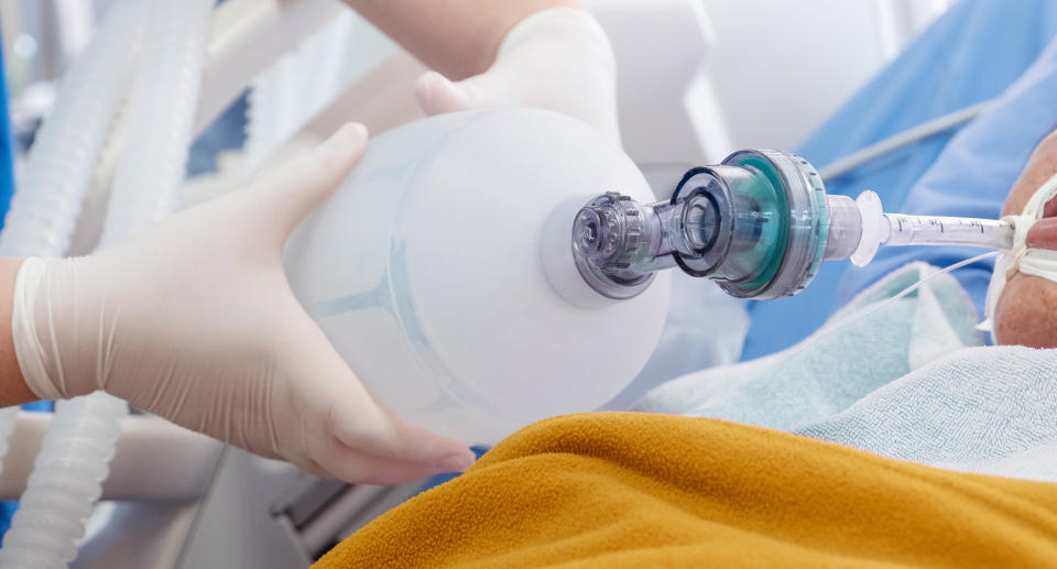 A doctor treats a patient who is struggling to get oxygen with a bag valve mask.