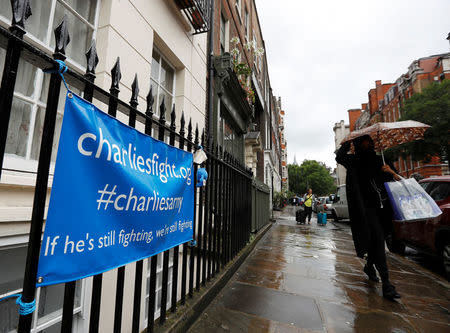 A woman walks past a banner left by supporters of Charlie Gard's family opposite Great Ormond Street Children's Hospital in London, Britain, July 27, 2017. REUTERS/Peter Nicholls