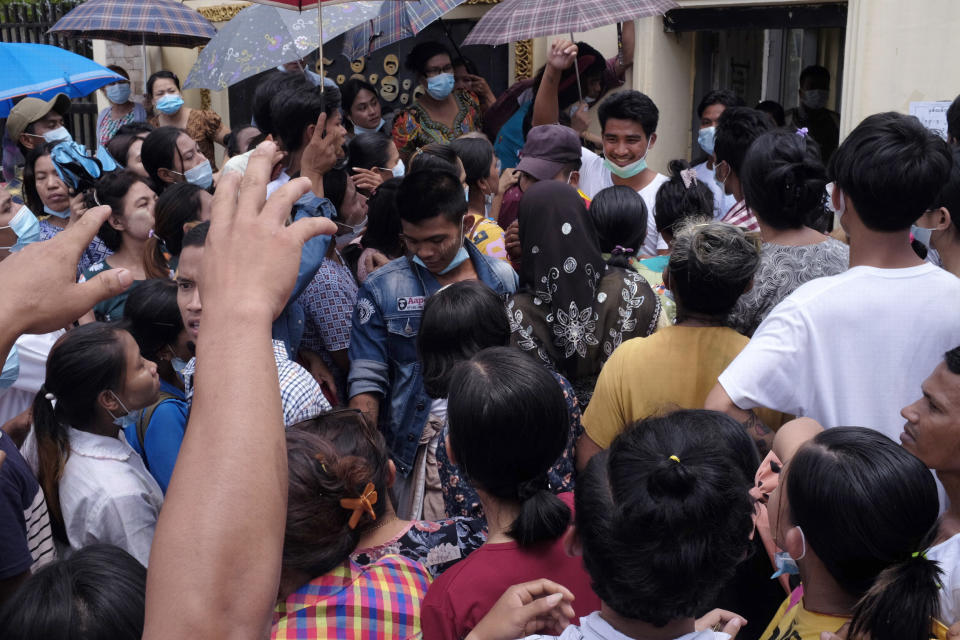 A man, rear, smiles amidst a waiting crowd as he steps out of Insein prison in Yangon, Myanmar Saturday, April 17, 2021. Myanmar's junta on Saturday announced it pardoned and released more than 23,000 prisoners to mark the new year holiday, but it wasn't immediately clear if they included pro-democracy activists who were detained in the wake of the February coup. (AP Photo)