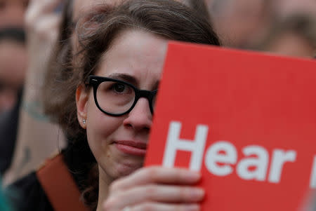 A protester holds a sign against the confirmation of U.S. Supreme Court nominee Judge Brett Kavanaugh outside the U.S. Capitol ahead of the scheduled Senate confirmation vote in Washington, U.S., October 6, 2018. REUTERS/Carlos Barria