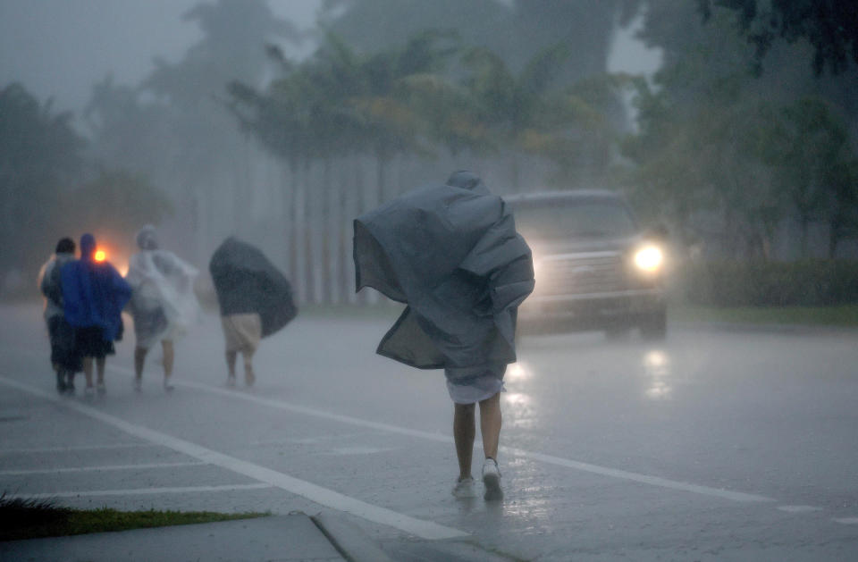 FILE - A group of people in raincoats walk east along Hollywood Boulevard in the pouring rain on April 12, 2023, in Hollywood, Fla. Over 25 inches of rain fell in South Florida since Monday, causing widespread flooding. (Mike Stocker/South Florida Sun-Sentinel via AP, File)