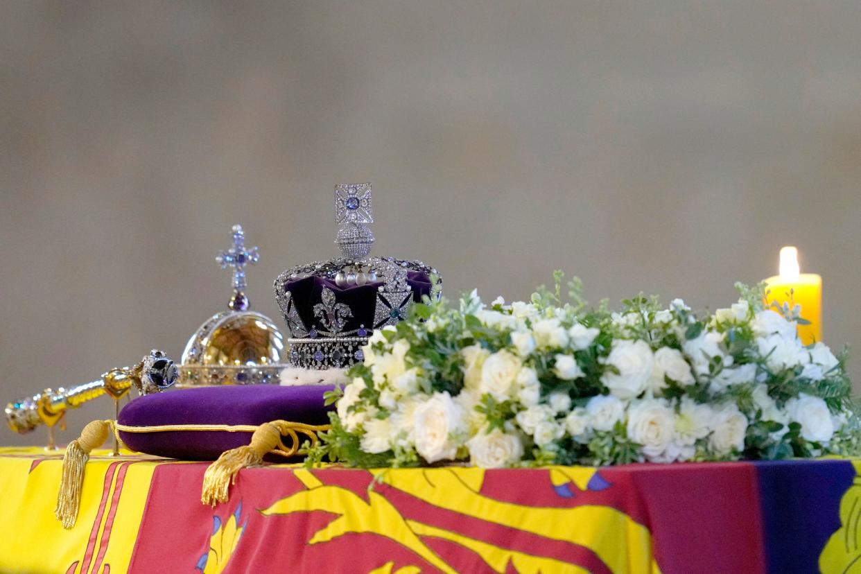 TOPSHOT - The coffin of Queen Elizabeth II, draped in the Royal Standard with the Imperial State Crown and the Sovereign's orb and sceptre, Lies in State on the catafalque as members of the public move past in Westminster Hall, at the Palace of Westminster, in London on September 16, 2022. - Queen Elizabeth II will lie in state in Westminster Hall inside the Palace of Westminster, until 0530 GMT on September 19, a few hours before her funeral, with huge queues expected to file past her coffin to pay their respects. (Photo by Kirsty Wigglesworth / POOL / AFP) (Photo by KIRSTY WIGGLESWORTH/POOL/AFP via Getty Images)