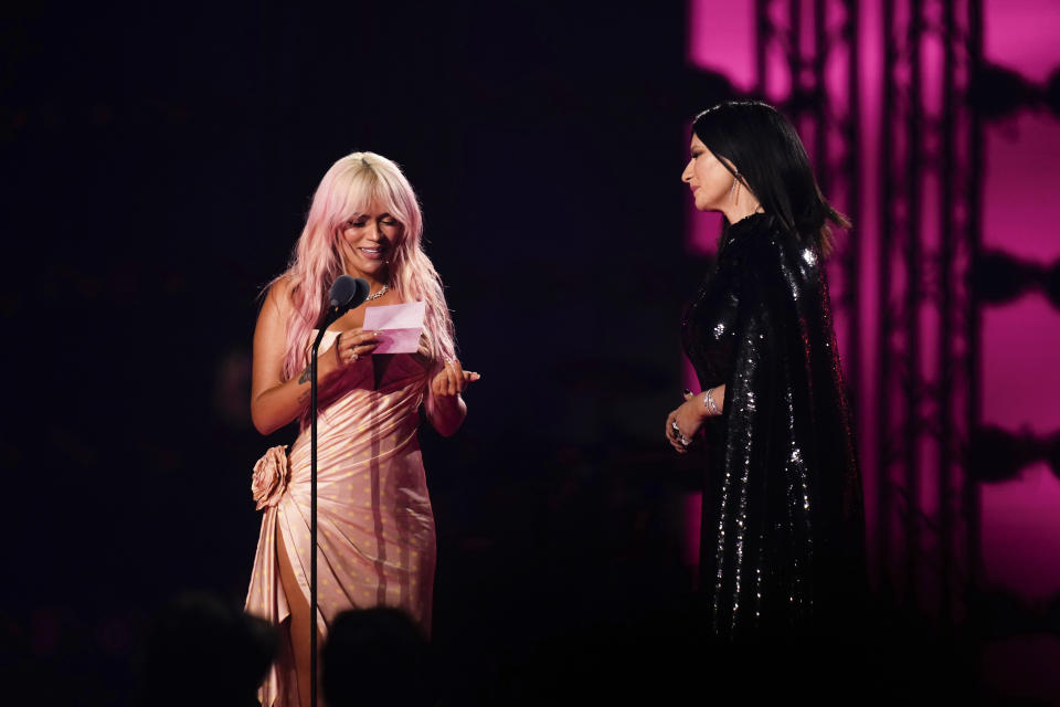 Karol G, left, presents the award for person of the year to Laura Pausini during the 24th annual Latin Grammy Awards in Seville, Spain, Thursday, Nov. 16, 2023. (Photo by Jose Breton/Invision/AP)