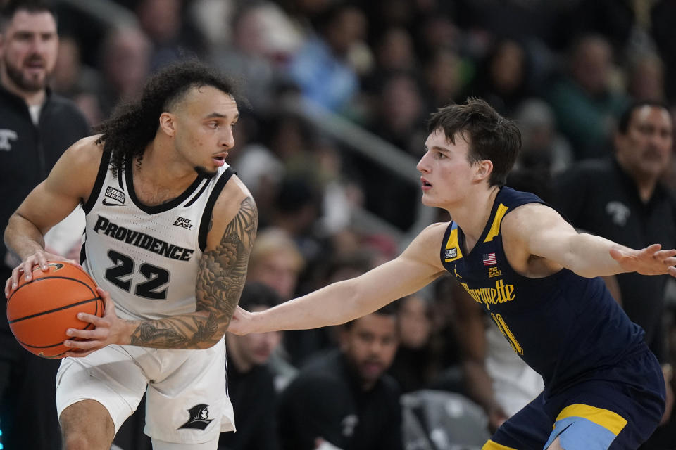 Providence guard Devin Carter (22) looks for an opening around Marquette guard Tyler Kolek during the second half of an NCAA college basketball game Tuesday, Dec. 19, 2023, in Providence, R.I. (AP Photo/Steven Senne)