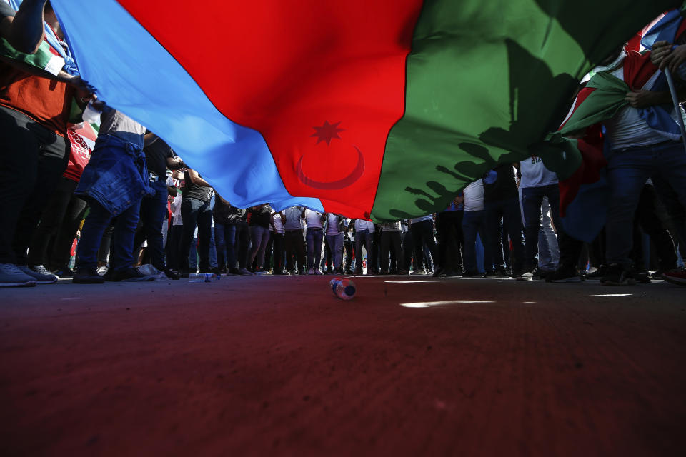 Demonstrators hold an Azerbaijani flag during a protest supporting Azerbaijan, in Istanbul, Sunday, Oct. 4, 2020. Armenian and Azerbaijani forces continue their fighting over the separatist region of Nagorno-Karabakh, following the reigniting of a decades-old conflict. Turkey, which strongly backs Azerbaijan, has condemned an attack on Azerbaijan's second largest city Gence and said the attack was proof of Armenia's disregard for law. (AP Photo/Emrah Gurel)