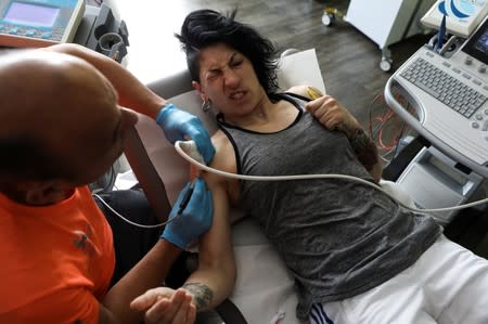 Miriam Gutierrez "La Reina", 36, reacts with pain in her shoulder during a physical therapy session in Paracuellos del Jarama