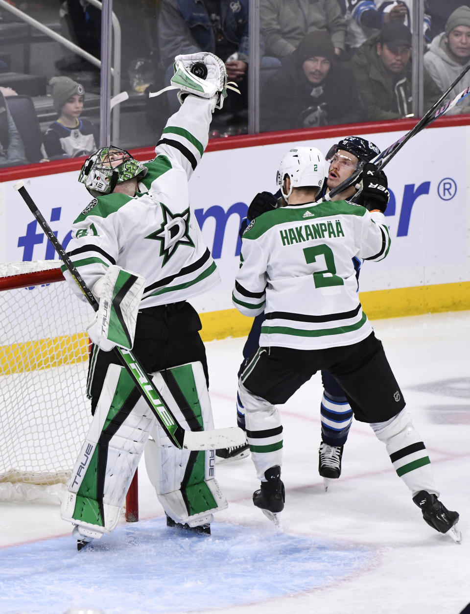 Dallas Stars' goaltender Scott Wedgewood (41) gloves a bouncing puck in front of Winnipeg Jets' Mason Appleton (22) and Stars' Jani Hakanpaa (2) during the third period of an NHL hockey match in Winnipeg, Manitoba, on Saturday, Nov. 11, 2023. (Fred Greenslade/The Canadian Press via AP)