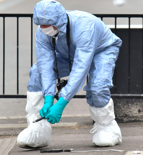 Forensics teams pick up the knives that were allegedly found with on the suspect (PA)