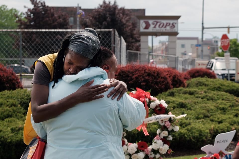 People embrace near a memorial for the shooting victims outside of Tops grocery store on May 20, 2022 in Buffalo, New York.